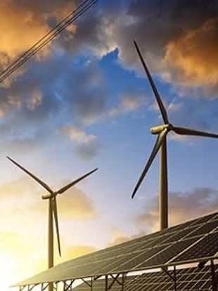 Aerogeneradores, paneles solares y línea de alta tensión al atardecer
